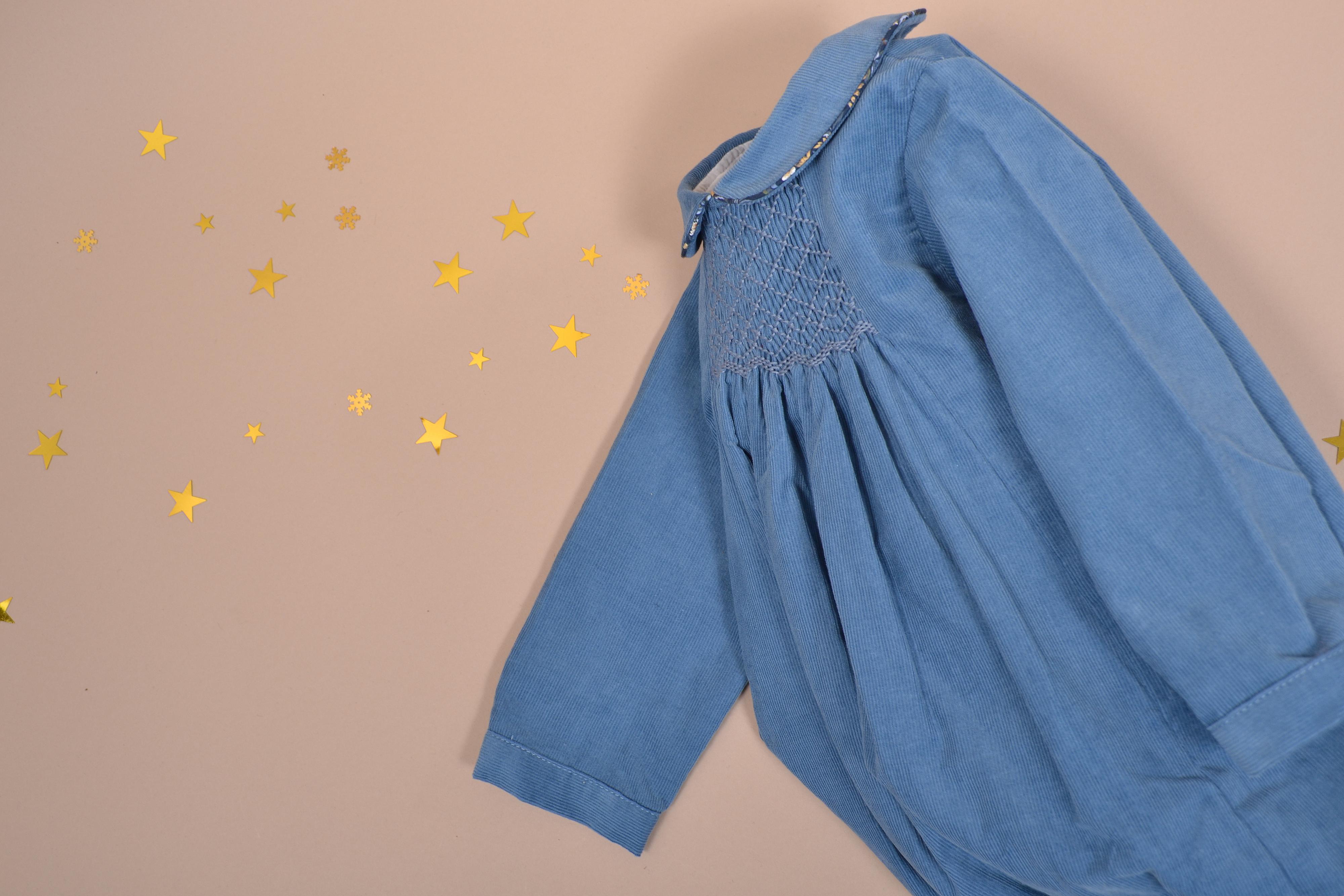 Caleb, Long-sleeved baby romper, Peter Pan collar with Liberty trim, smocked in front, in Blue porcelaine corduroy