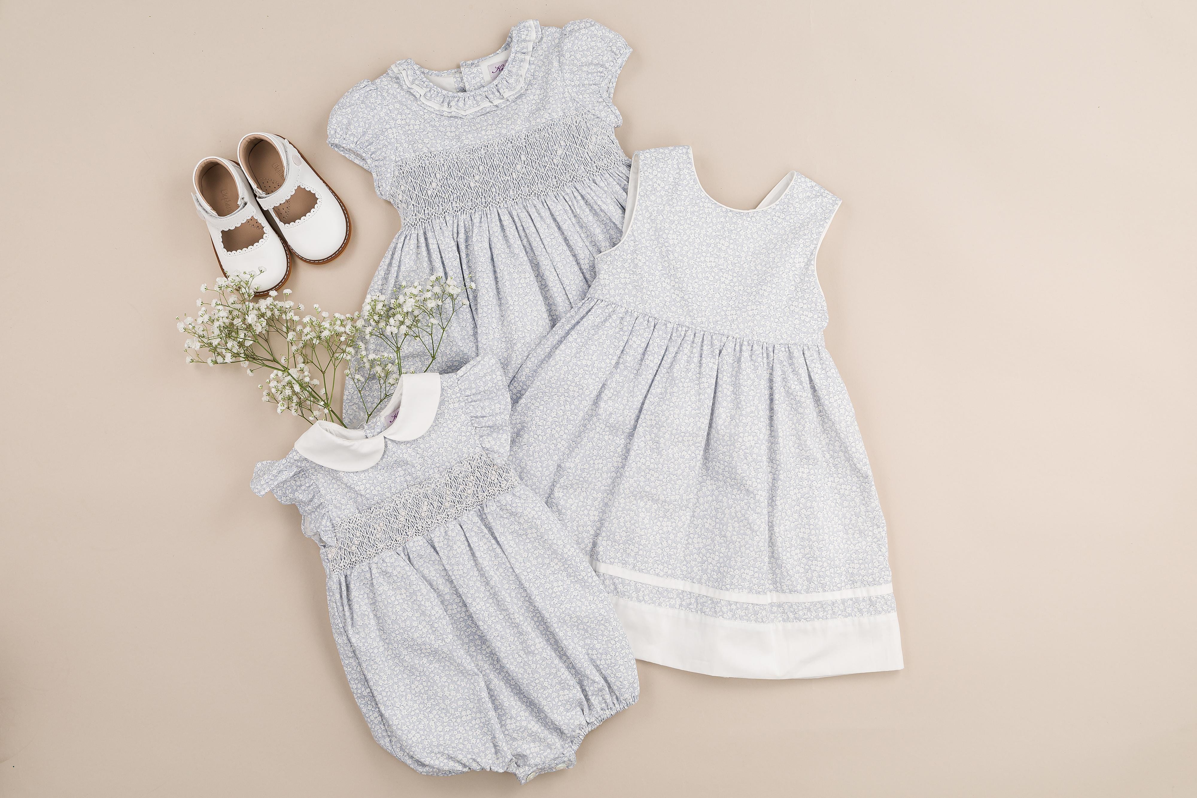 Julyne , smocked baby girl romper with ruffled sleeves and white Peter Pan collar, in Small sky blue print