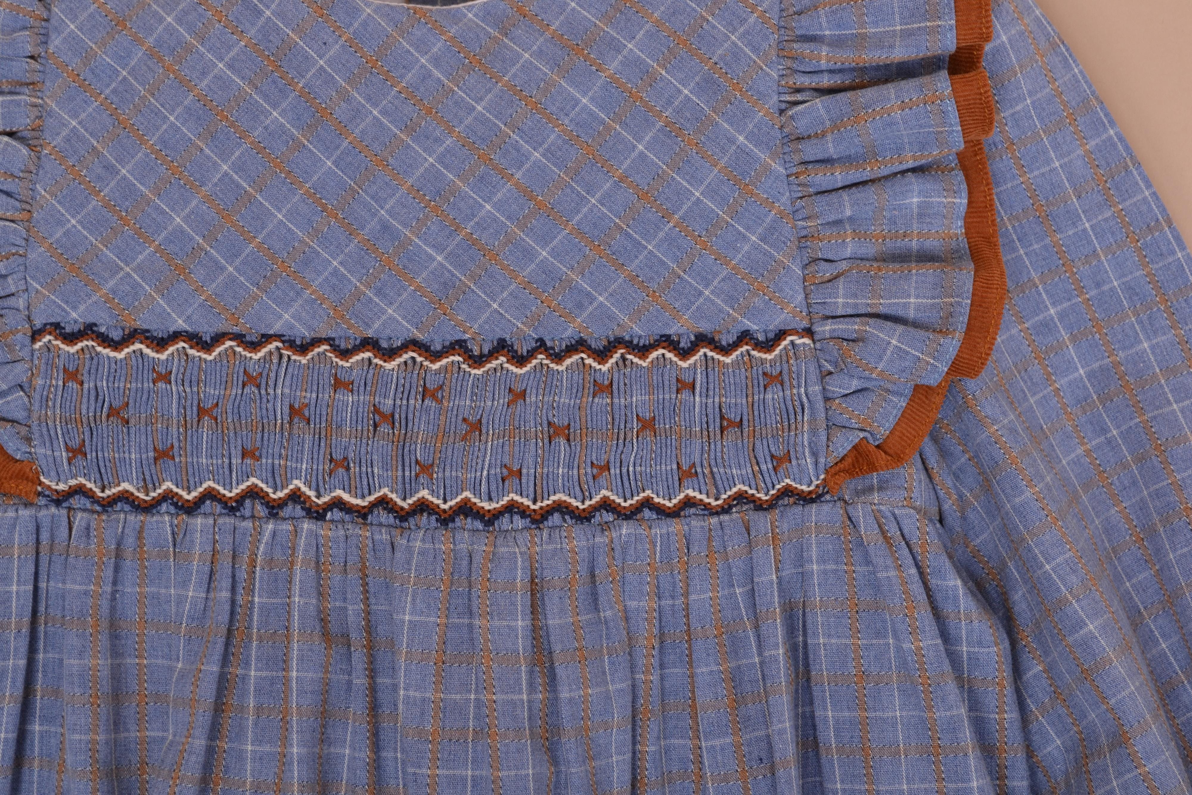 Robe Valentine, encolure ronde, doubles volants sur les épaules, smockée à la taille, en Tartan bleu et cannelle -Valentine dress, round neckline, double ruffles on the shoulders, smocked at the waist, in Blue and cinnamon Tartan