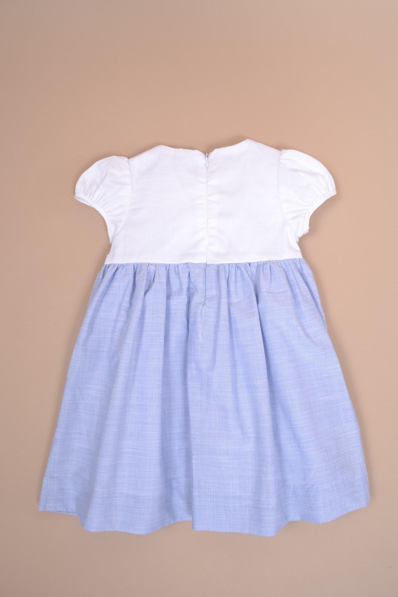 Festony, balloon-sleeved dress top in scalloped white cotton piqué, smocked bottom and embroidered at the waist in 1mm blue and white stripes