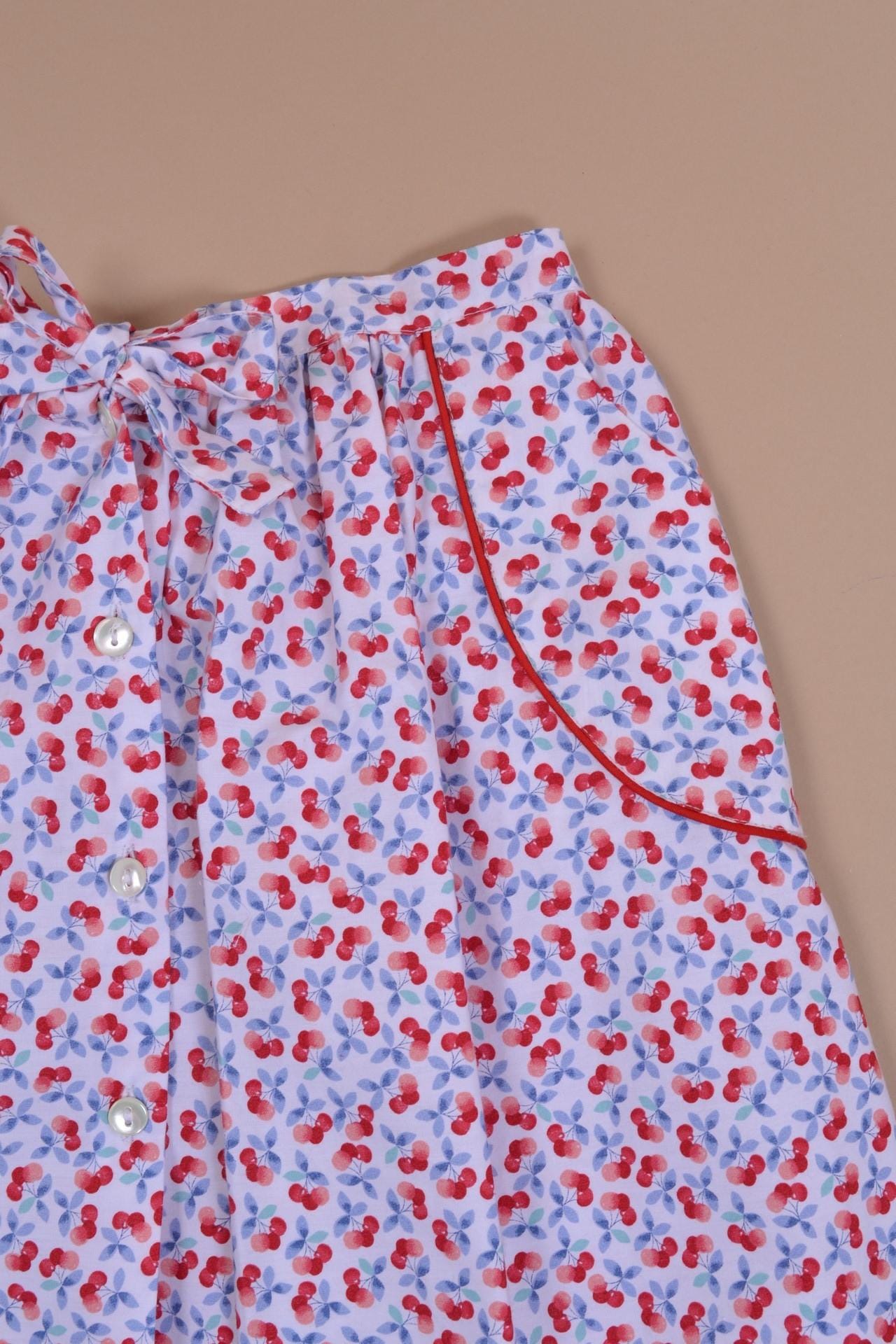 Jasmin, jupe poches passepoilées rouges, ouverte sur le devant, en imprimé cerises bleues et rouges - red piped pocket skirt, open at the front, in blue and red cherry print